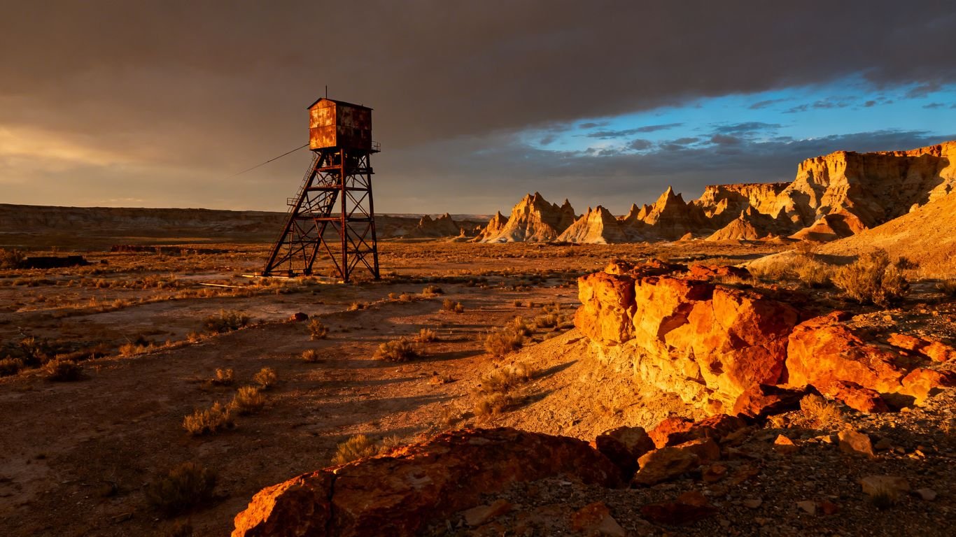 Mine d'uranium dans un paysage aride sous un ciel dramatique.